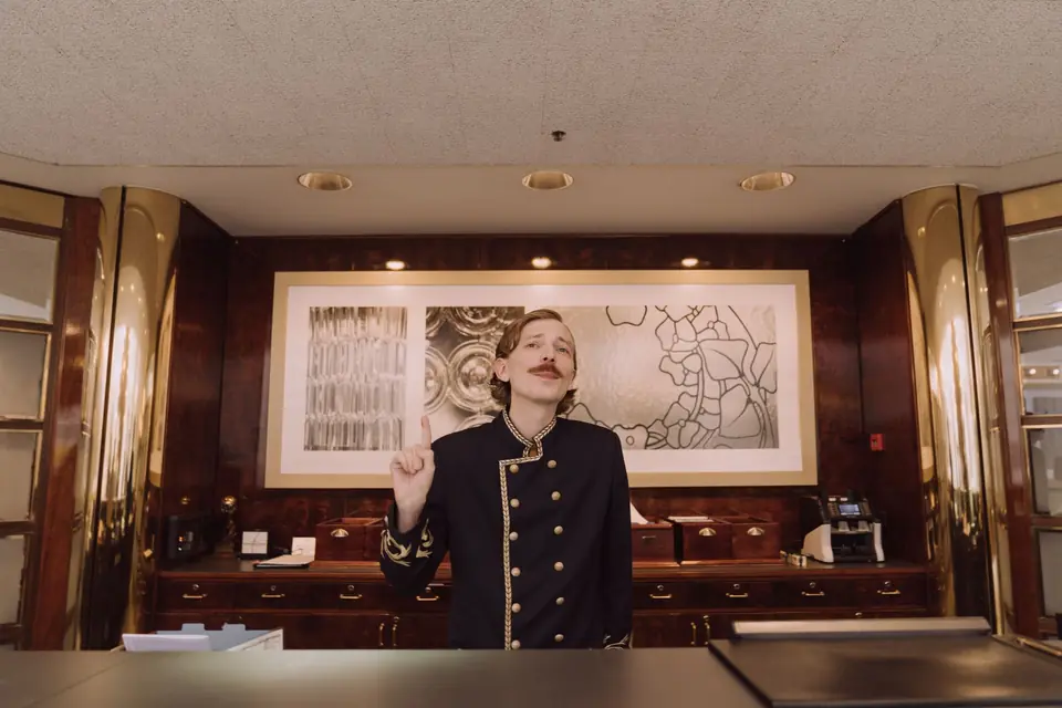 Rezeptionist in Uniform hinter dem Empfangstresen eines Hotels